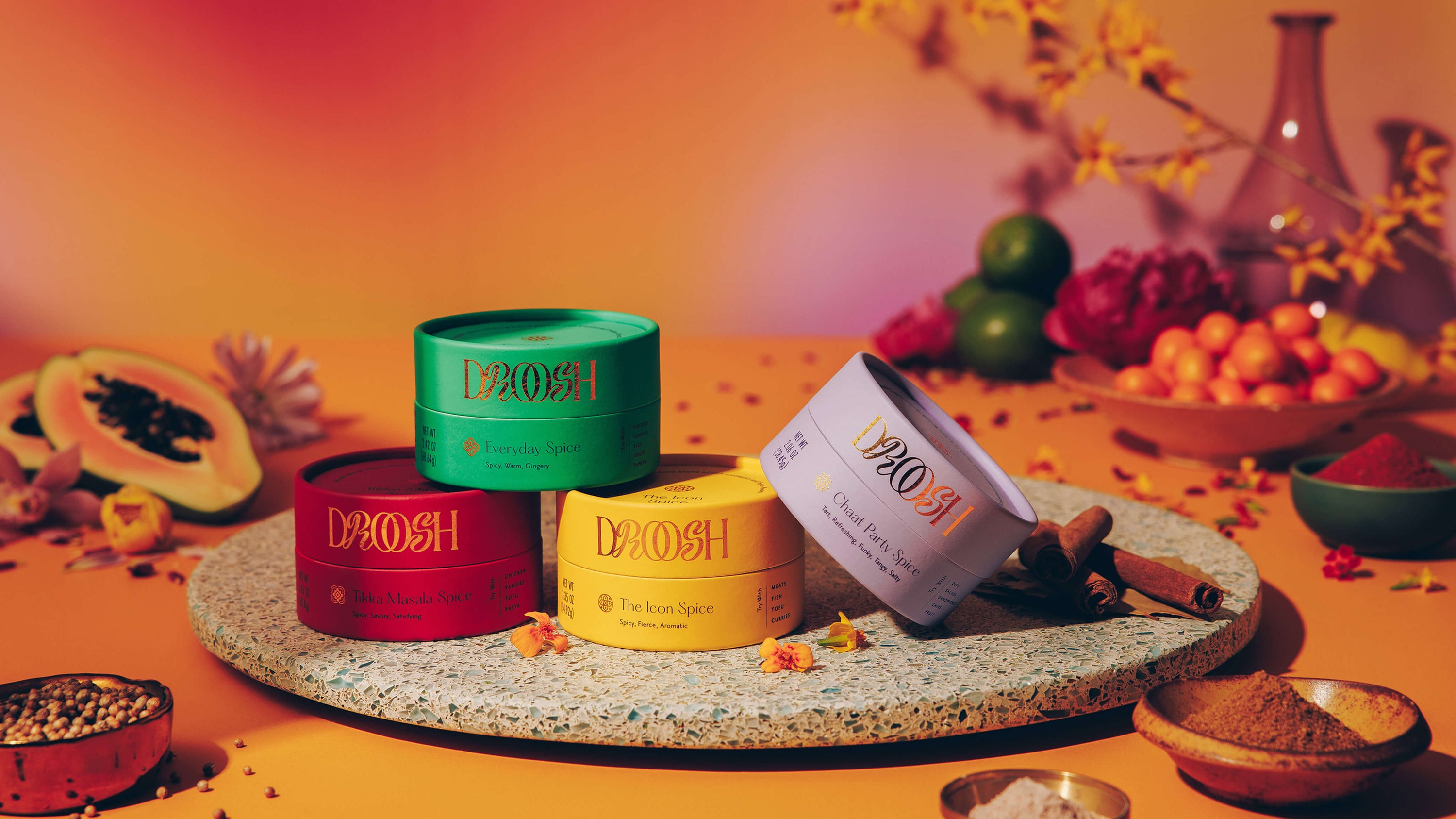 Showcase of Variety of Droosh Spices mounted on a table together with fruits and natural elements in warm colors